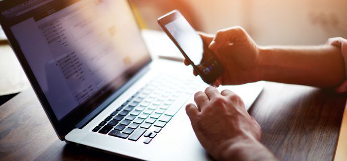 Side view of a man's hands using smart phone in interior at his